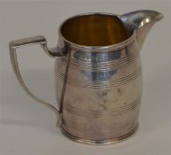 A Georgian barrel shaped cream jug with gilt inter