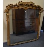 A large gilt over mantle mirror decorated with scr