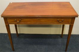 A mahogany fold over tea table on tapering support