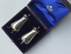 A boxed pair of silver peppers with reeded decorat