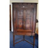 A Georgian oak corner cabinet on base with secret