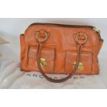 A brown leather Marc Jacobs handbag with white dus