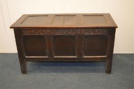 An Antique oak hinged top coffer with carved front