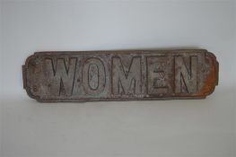 A cast iron railway toilet door sign, "Women". Est