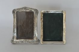 Two silver picture frames with scroll decoration.