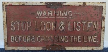A cast iron "Stop, Look and Listen" warning sign.