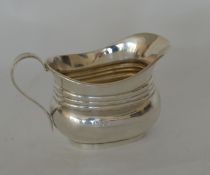 A small silver cream jug with fluted body. London.