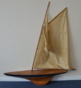 A wooden pond yacht with varnished deck and keel,