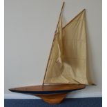 A wooden pond yacht with varnished deck and keel,