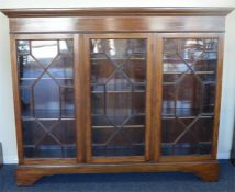 A large Edwardian three door bookcase on bracket f