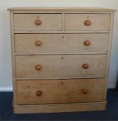 A good stripped pine chest of five drawers on pede