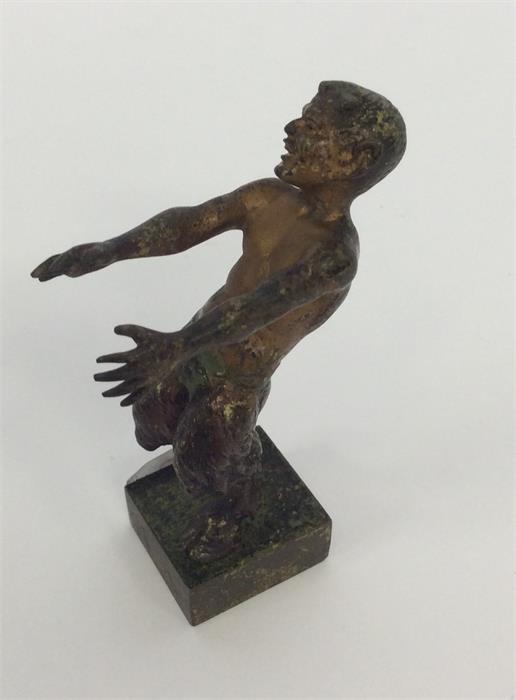 A small cast bronze of a man with textured body an