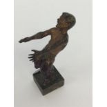 A small cast bronze of a man with textured body an