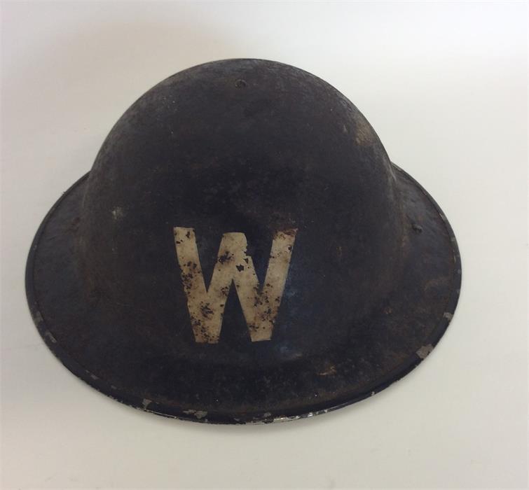 An old World War II warden's helmet. Est. £10 - £15.