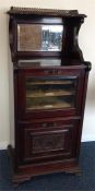 A small Edwardian glazed front music cabinet with