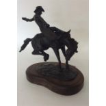 An unusual heavy brass figure of a cowboy on leapi