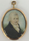 An oval gold framed miniature of a gent with loop