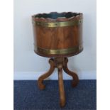 A walnut and brass bound planter on four spay supp