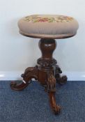 A mahogany tapestry topped piano stool with carved