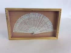 An attractively carved fan in glazed gilt case. Es