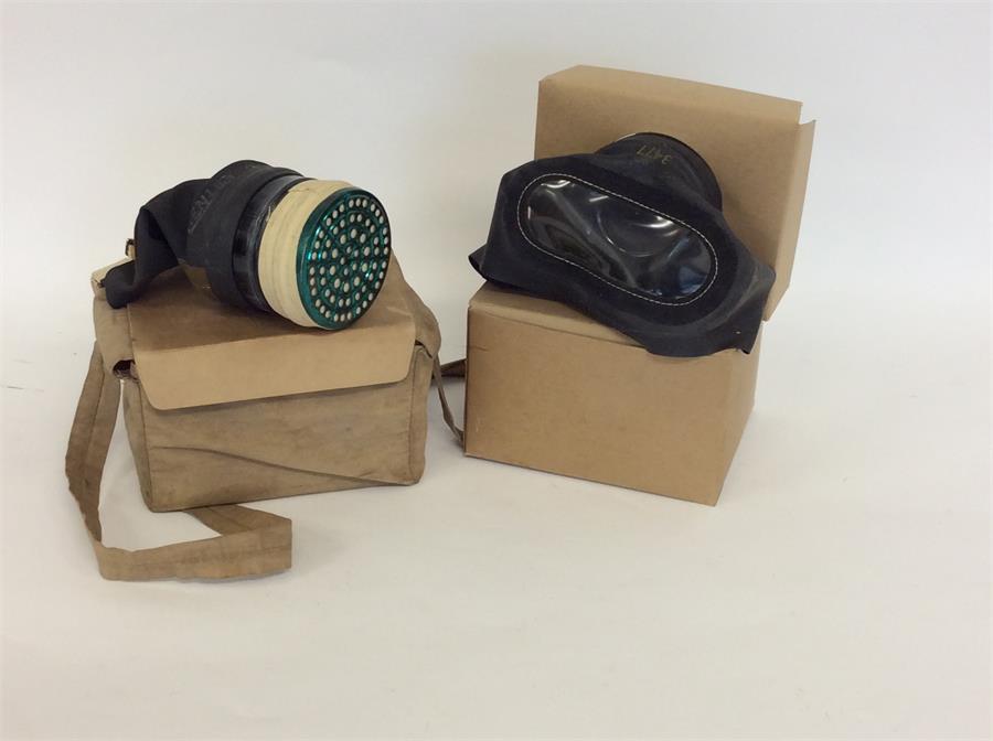 Two World War II gas masks. Est. £20 - £30.