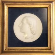 A circular plaque of a lady's head in gilt frame.