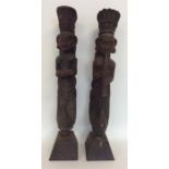 A pair of tall carved painted door stops of South