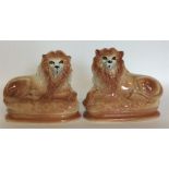 A pair of Staffordshire lions on textured base. Es