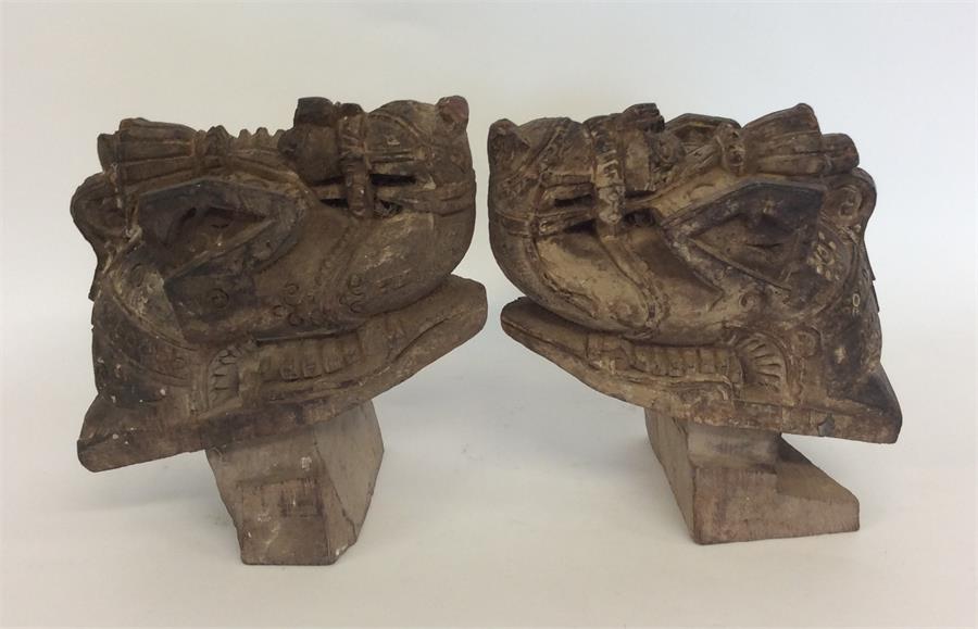 A pair of carved wooden figures of camels with tex