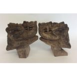 A pair of carved wooden figures of camels with tex