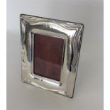 A large modern silver picture frame of wavy design
