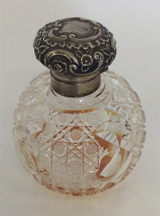 A large hobnail cut scent bottle with embossed lid