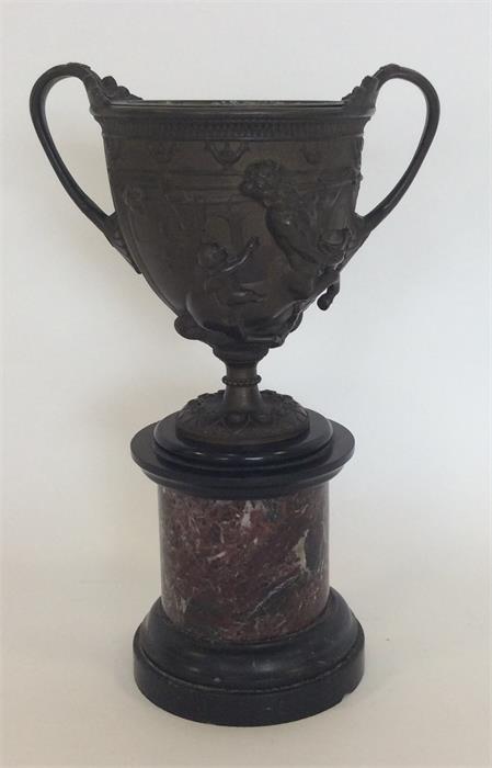 A 19th Century two handled bronze urn with brass c