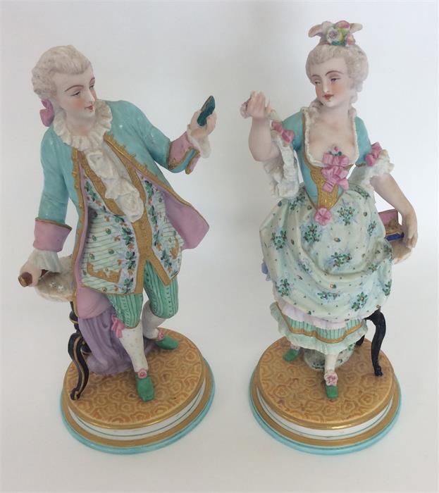 A pair of decorative figures of dancers with flora