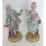 A pair of decorative figures of dancers with flora