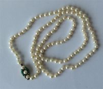 A long string of pearl beads with turquoise boat s