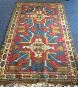 A large Eastern rug with red ground centre and tas