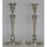 A tall pair of candlesticks with panelled sides an