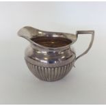 A silver half fluted cream jug with gilt interior