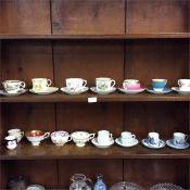 Two shelves of decorative cabinet cups and saucers