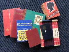 A collection of stamp albums, cigarette cards, and