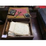 A writing slope together with daguerreotypes.