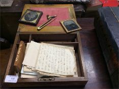 A writing slope together with daguerreotypes.