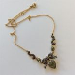 A peridot and rose diamond pendant with bow and he