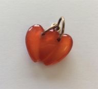 A Corneliun carved double heart charm with loop to