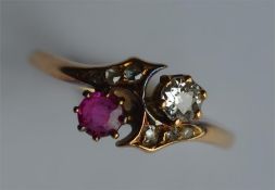 A ruby and diamond two stone crossover ring. Appro