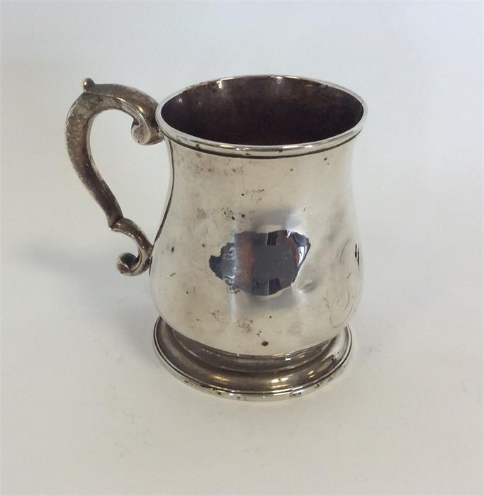 A George II tapering mug with scroll decorated han