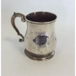 A George II tapering mug with scroll decorated han