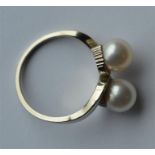 A gold two stone pearl crossover ring. Approx. 3.7