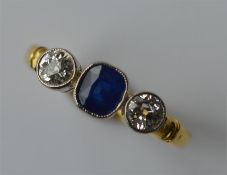 A sapphire and diamond three stone ring in 18 cara